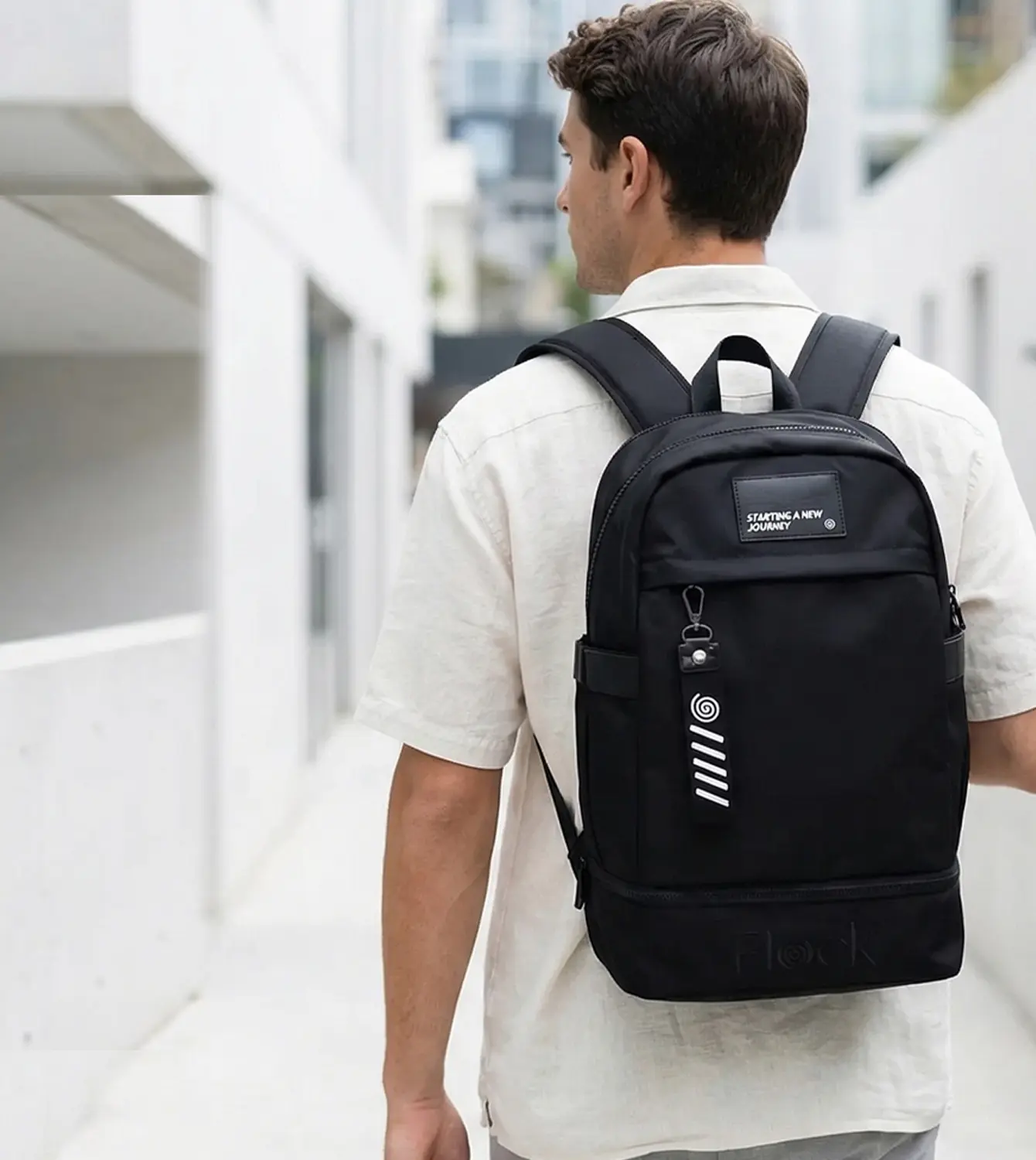 Persona cargando mochila negra en calle blanca urbana